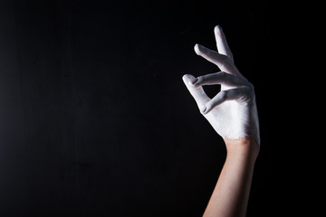 White painted hand on a black background. Abstract. Copy space