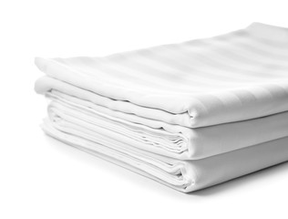 Stack of clean bed sheets on white background