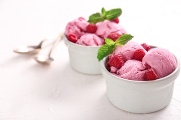 Bowls with tasty raspberry ice-cream on white background