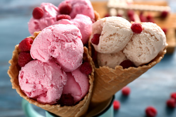 Waffle cones with tasty raspberry ice-cream on blurred background, closeup