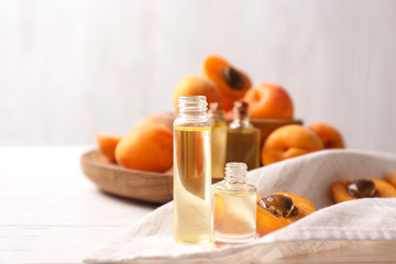 Bottles with apricot essential oil on table