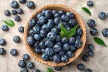 Bowl with ripe blueberries on light table