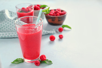 Glass of tasty raspberry smoothie on table