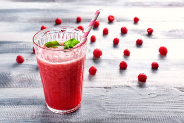 Glass of tasty raspberry smoothie on wooden table