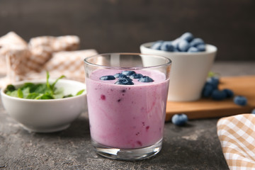 Glass of tasty blueberry smoothie on table