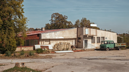 abandoned building and old car in the yard