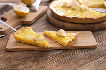 Pieces of tasty lemon pie on wooden table