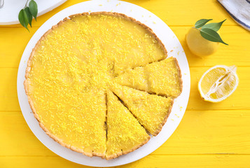 Tasty cut lemon pie on table