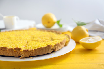Tasty cut lemon pie on table, closeup