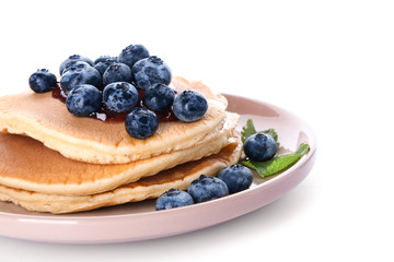 Fototapeta premium Plate with tasty pancakes and blueberries on white background, closeup