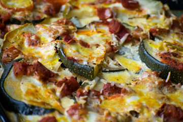 Casserole with zucchini, tomatoes and eggs on a baking sheet. Juicy casserole with courgettes.