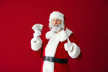 Fototapeta na wymiar Santa Claus with dollar banknotes on color background