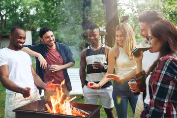 Group of friends making barbecue in the backyard. concept about good and positive mood with friends
