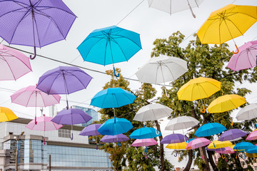 Fototapeta na wymiar The street of a modern city is decorated with colorful umbrellas_