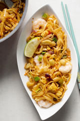 Pad thai noodles with prawns, mixed greens, chopped peanuts, shallots & lime wedge