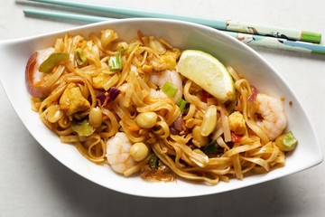 Pad thai noodles with prawns, mixed greens, chopped peanuts, shallots & lime wedge