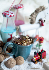 Christmas milk in bottles and holiday sweets. New Year party. Colored milk and straws,