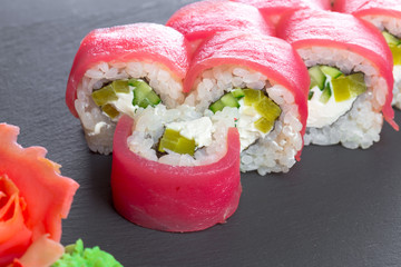 Japanese restaurant, sushi roll on black slate plate.