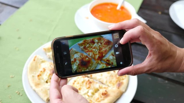 Food photo take picture of dish via smart phone camera in restaurant for social media
