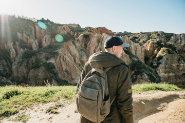 A tourist with a backpack or traveler walks through the hilly terrain.