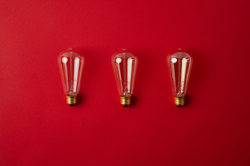 top view of row of vintage incandescent lamps on red tabletop