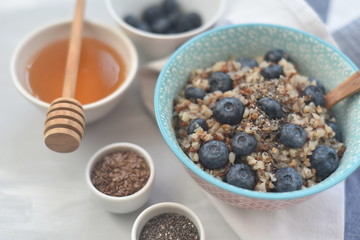 Buckwheat porridge in a bowl with flax seeds and blueberries. oncept healthy food, detox, diet,...