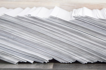 load at work: Huge stack of envelopes with working mail on the accountant's Desk, side view, tilted
