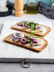 Danish open sandwich smorrebrod with salted herrings, red onion, butter. Traditional snack