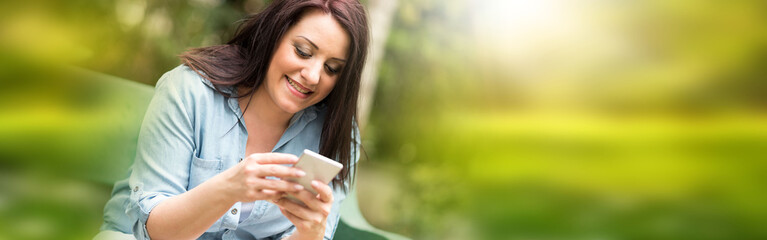 Portrait of happy young woman using her mobile phone
