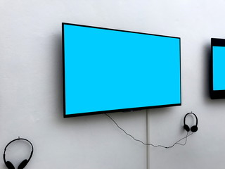  Blank screen LED TV with heaphones Gaming and entertainment concepts hanging on white background for billboard information or banner background use