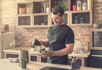handsome man pours freshly brewed coffee into cups