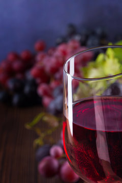 Close-up of glass with red wine and grapes