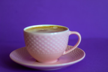 Pink coffee cup, purple background, selective focus