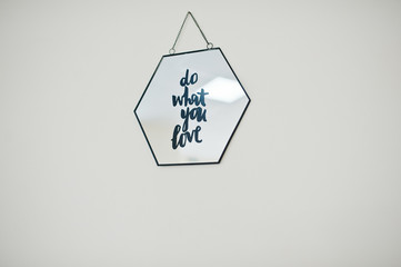 Framed picture with motivational saying on it on light background.
