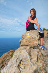 Naklejka premium Hiker woman relaxed on top of the mountain enjoying a beautiful landscape