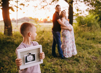 Happy young family in the park at sunset