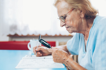 Senior woman enjoys solving a crossword puzzle