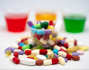 Colourful Pharmaceutical drugs, capsules, pills and tablets in medicine cups