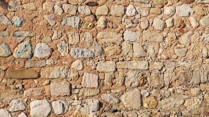 Brown wall built from large stones stacking upon one another