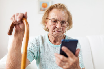 Elderly woman with glasses using a mobile phone