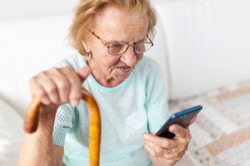 Elderly woman with glasses using a mobile phone