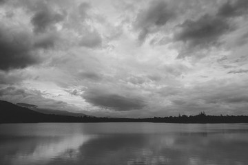 Fototapeta premium Black and white image of a beautiful lake with sky and mountain background