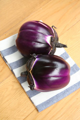 Raw round purple eggplants on wooden table. Summer vegetables
