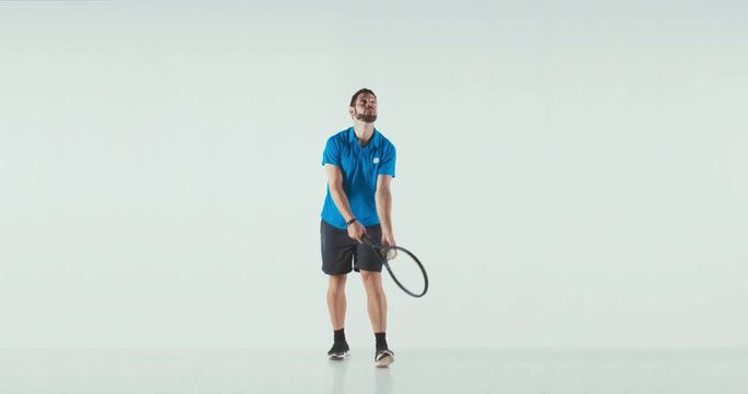 Caucasian male tennis player performing a tennis serve against white background. 4K UHD 60 FPS SLOW MOTION