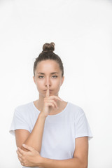 Fototapeta na wymiar Secretive young woman placing finger on lips asking shh, quiet, silence isolated white background. Human face expressions, sign emotion feeling body language reaction