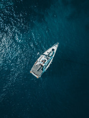 Sailboat shot from above showing the clear blue water of the mediterranean ocean