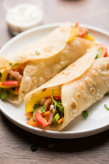 Indian Veg chapati Wrap / Kathi Roll, served in a plate with sauce over moody background. selective focus