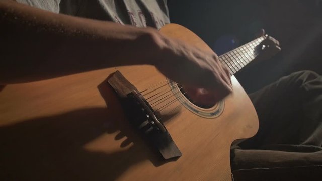 Man Plays An Acoustic Guitar In Dark Room