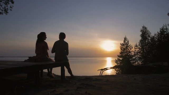 Young Woman Communicate Near The Sea And Watching Beautiful Sunset