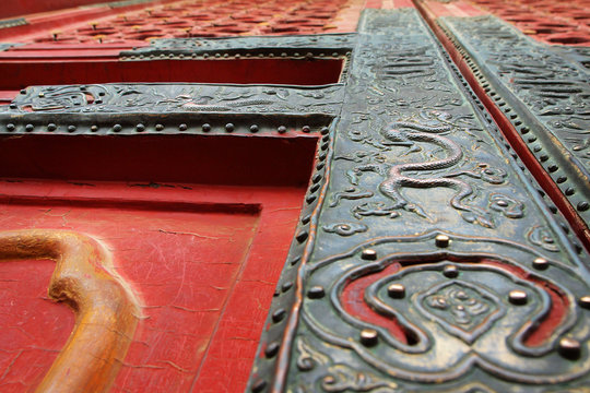 Door with metal dragon design carved  on wooden door of buddhist temple